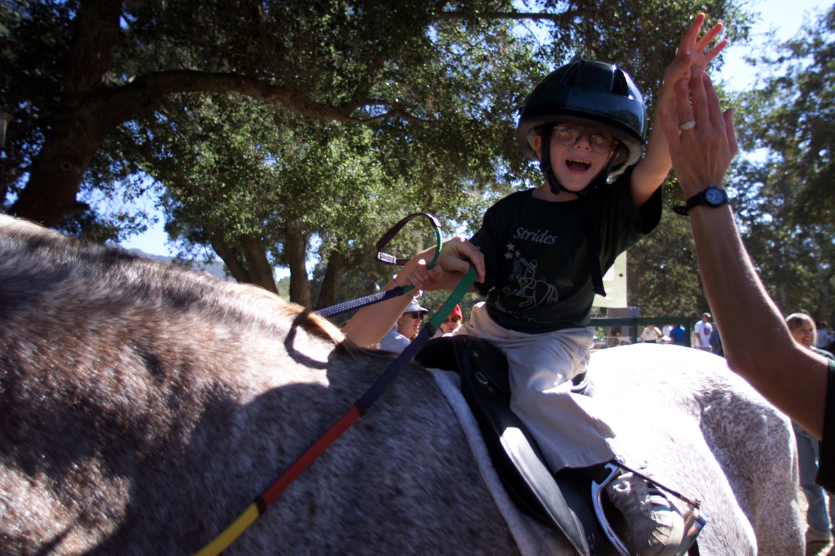 Young competitor Judd Tennant (cq), 5, who has cerebral palsey, gets a high five from his mom before