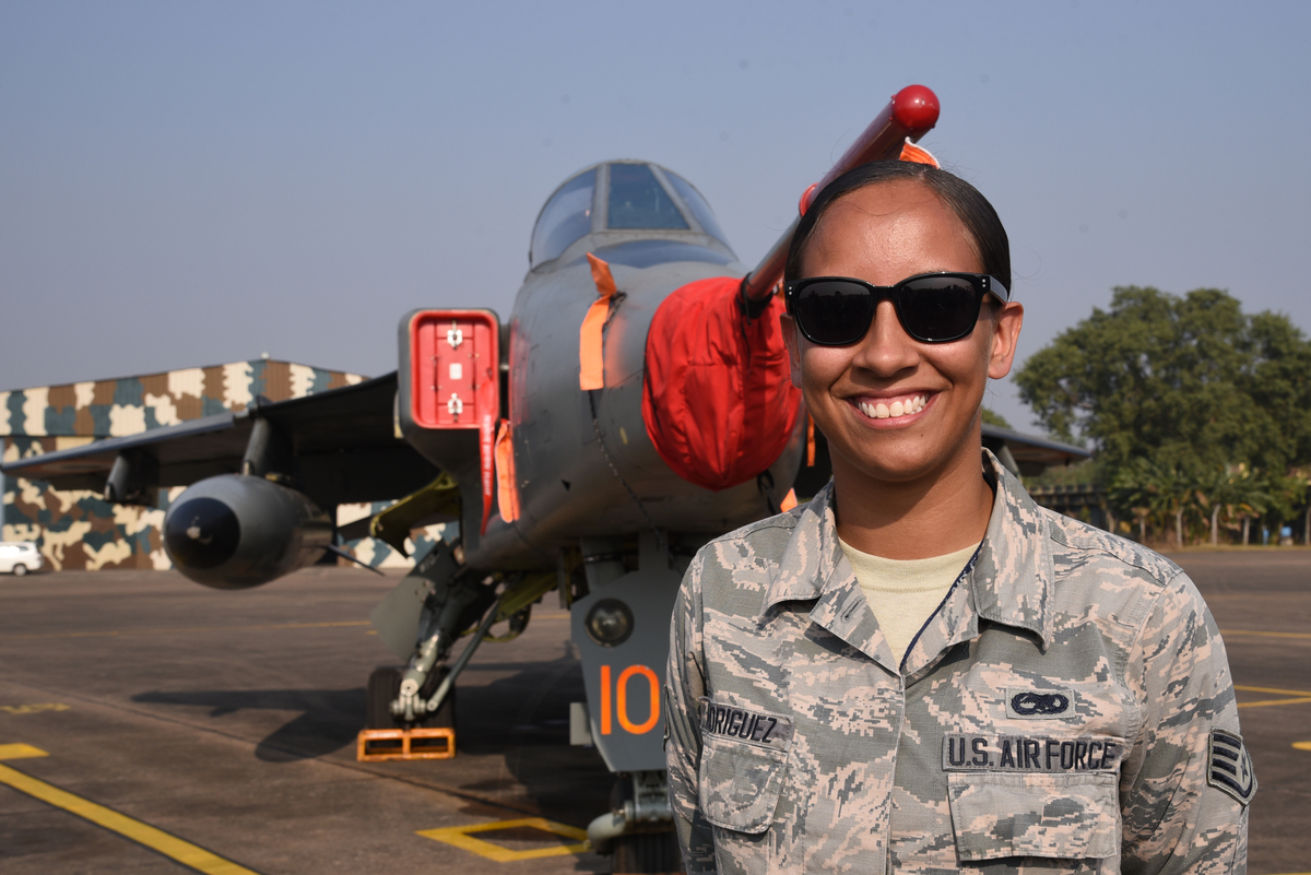A women Participating member from the Indian Air Force Hawk aircraft stand at the front of of US F-15 fighter aircraft