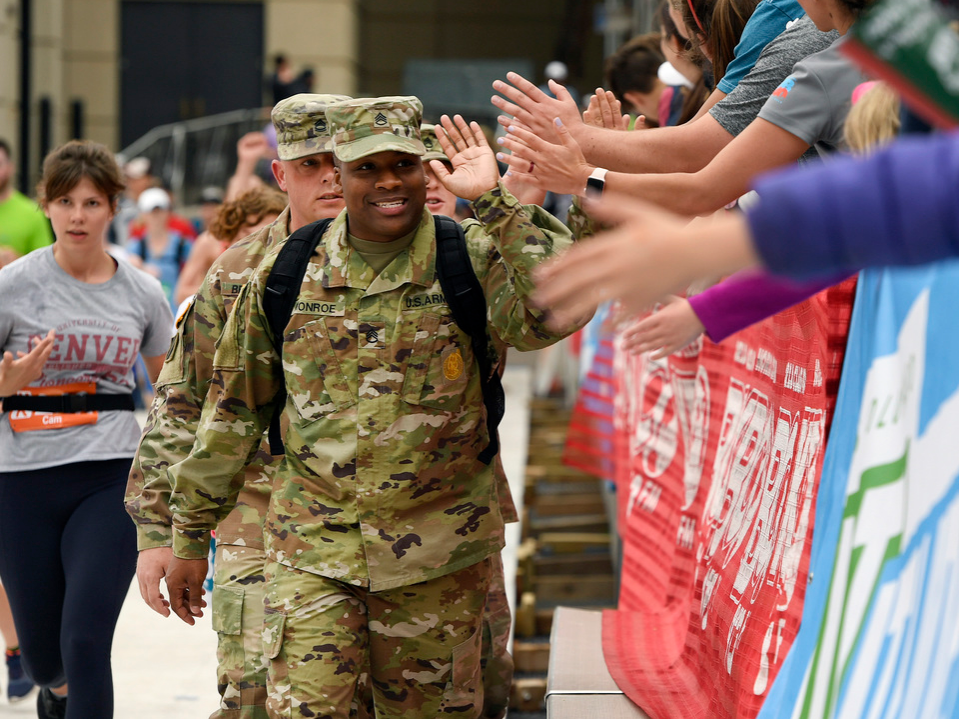 Army Sgt. Cordell Monroe gets high fives from people in the stadium during the Citizen's race of the Bolder Boulder 