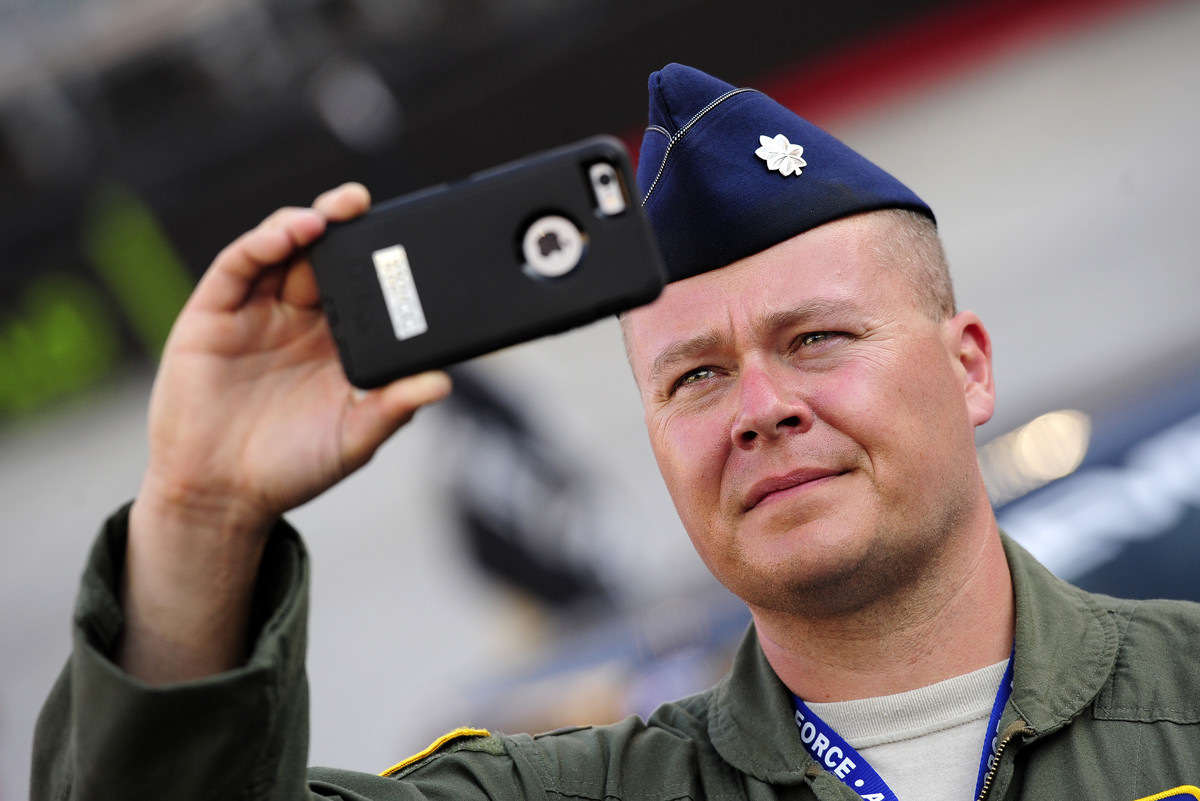 ir Force Lieutenant Colonel Terry Holmes records the pre-race festivities on his iPhone