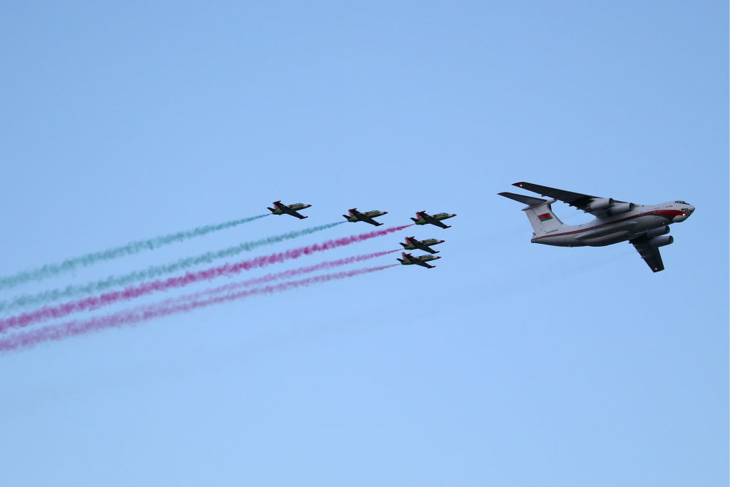 GettyImages-1153556449 An Ilyushin Il-76MD strategic airlifter and Aero L-39 Albatros trainer aircraft of the Belaya Rus aerobatic team leave a trail in the Belarusian national colours during a military parade