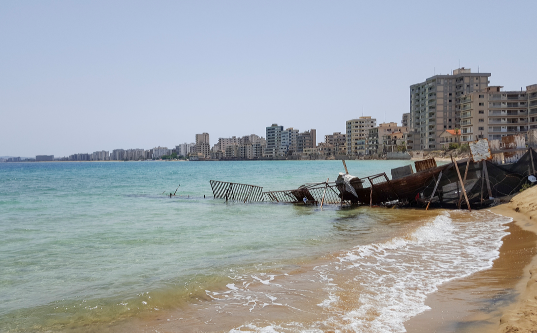 Abandoned hotel buildings stand beyond a makeshift barrier inside the 'Forbidden Zone' of Varosha, Cypress