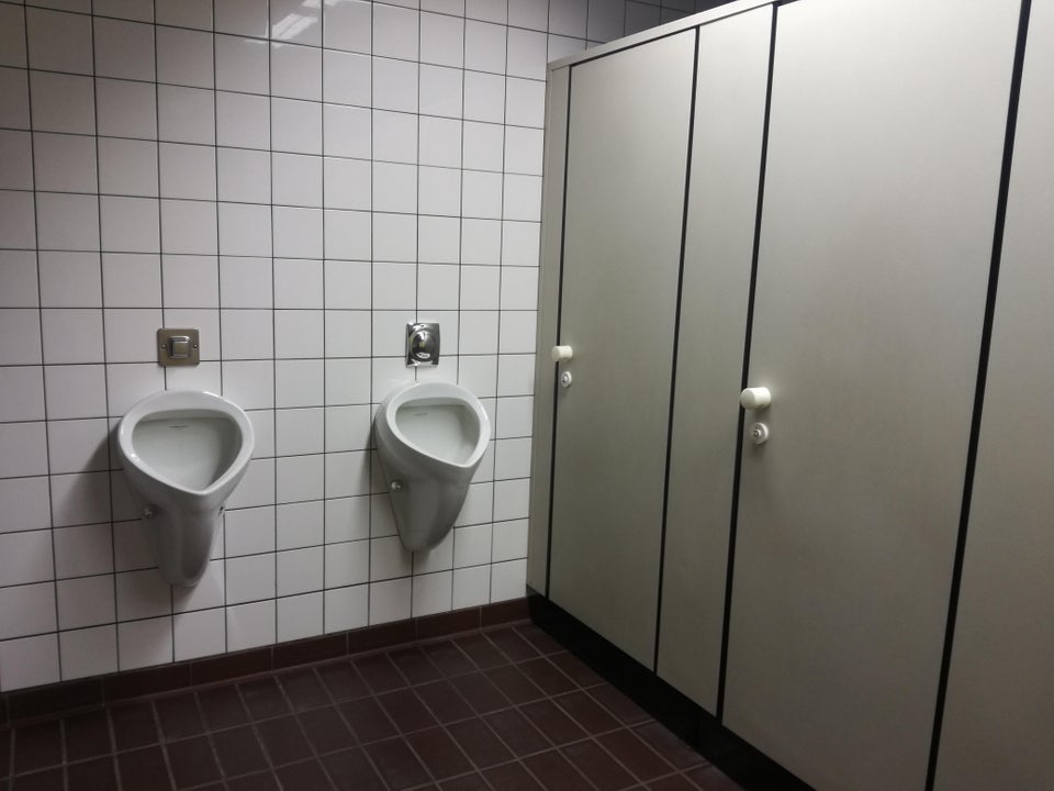 toilet urinals right in front of the bathroom stall 