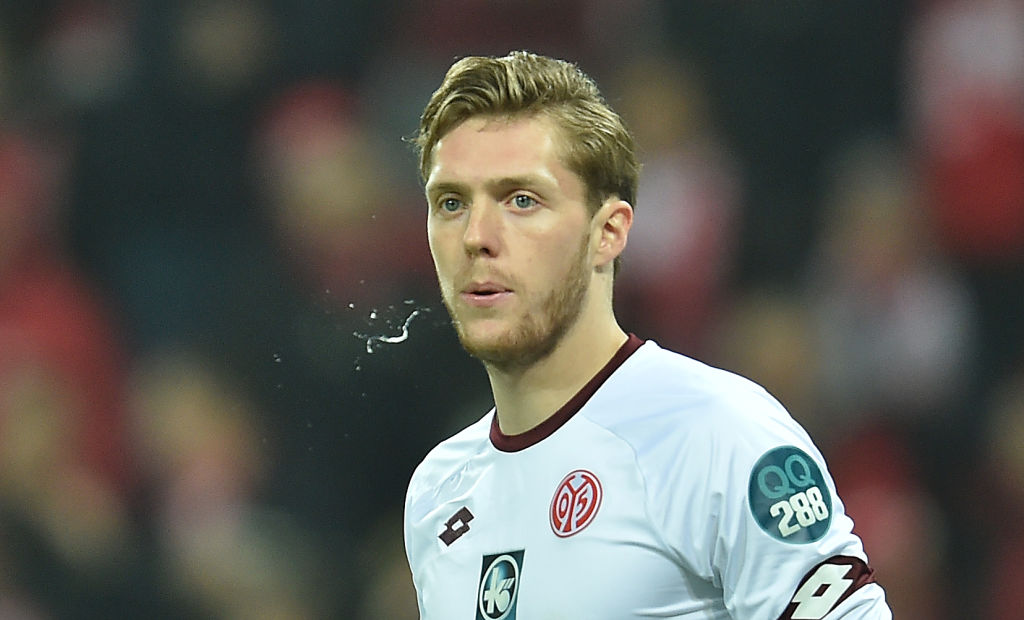 A soccer player is photographed with split flying out of his mouth