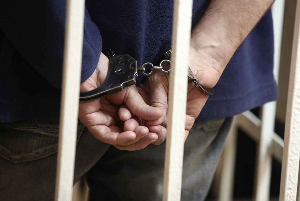 Man behind bars and handcuffed 