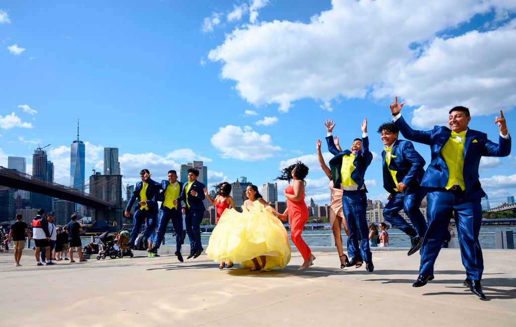 A colorful wedding party poses midair as they jump for a photo.