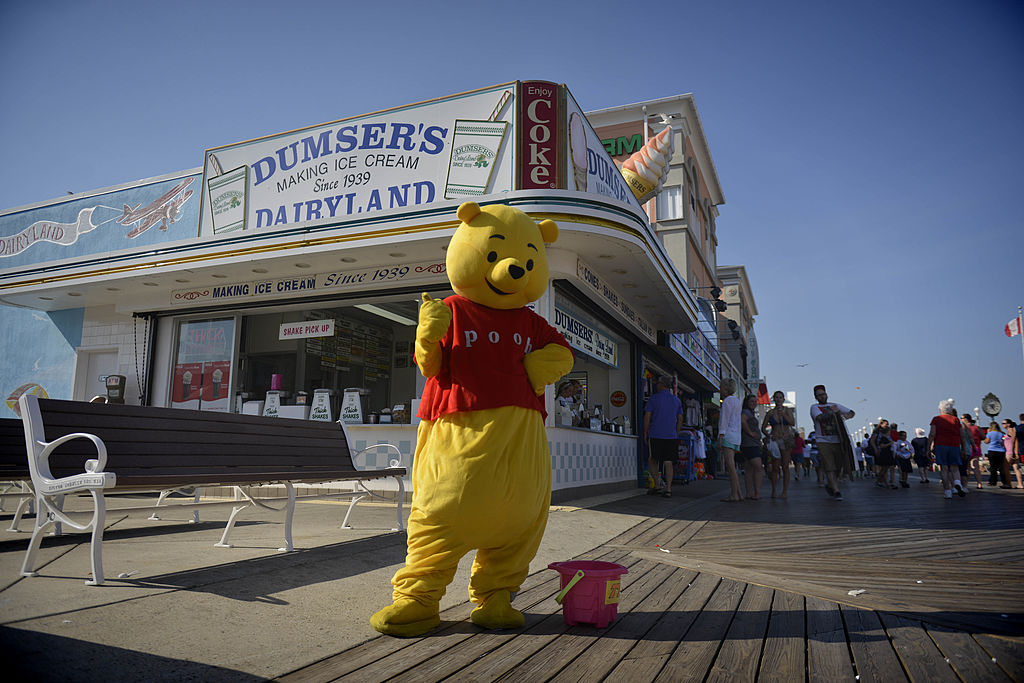 A Winnie The Pooh impersonater poses on the boardwalk.