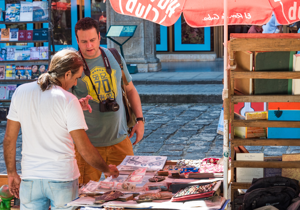 Tourist man browsing a souvenir stand in Cuba.