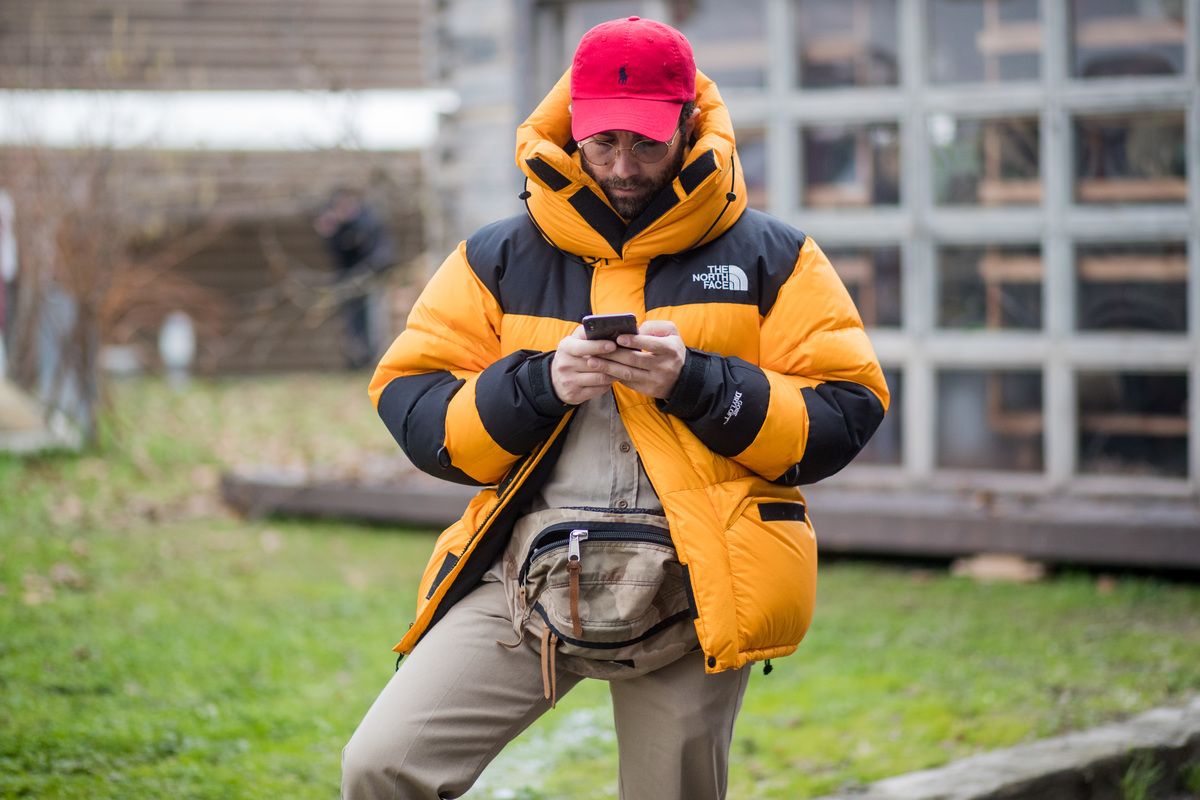 a man in a north face jacket on his phone
