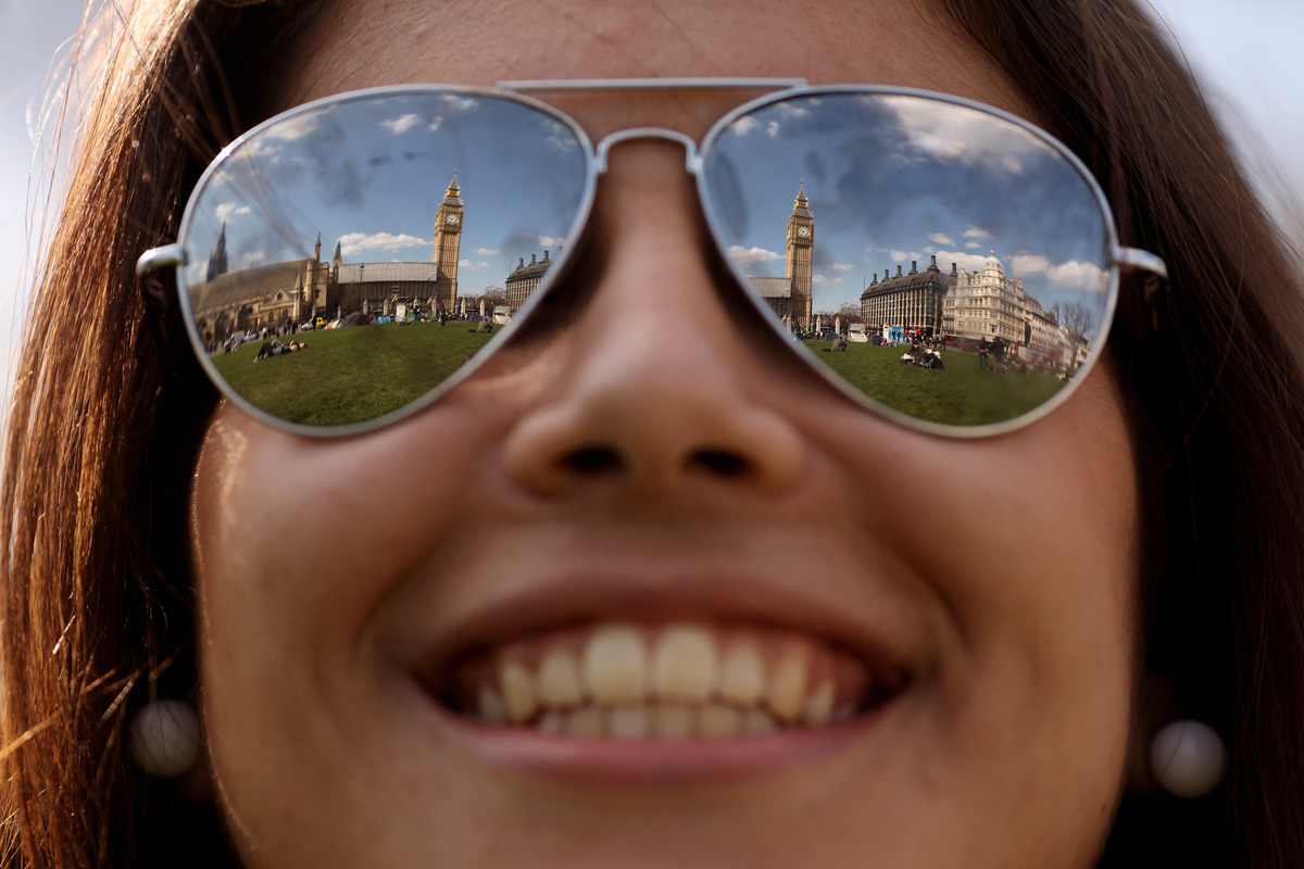 A tourist enjoys warm spring weather in Parliament Square on April 8, 2010 in London, England.