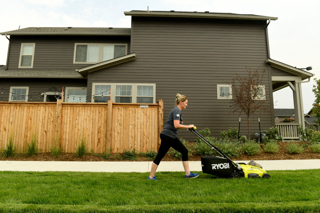 A woman mows her lawn