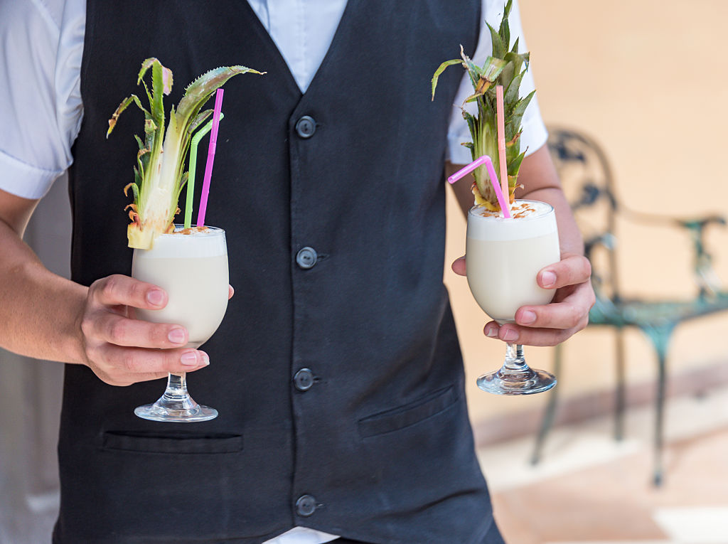 A server carries over a piña colada