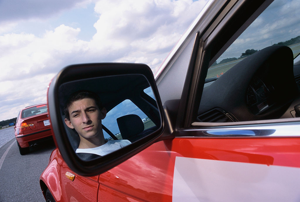 a teenager pictured in a red car