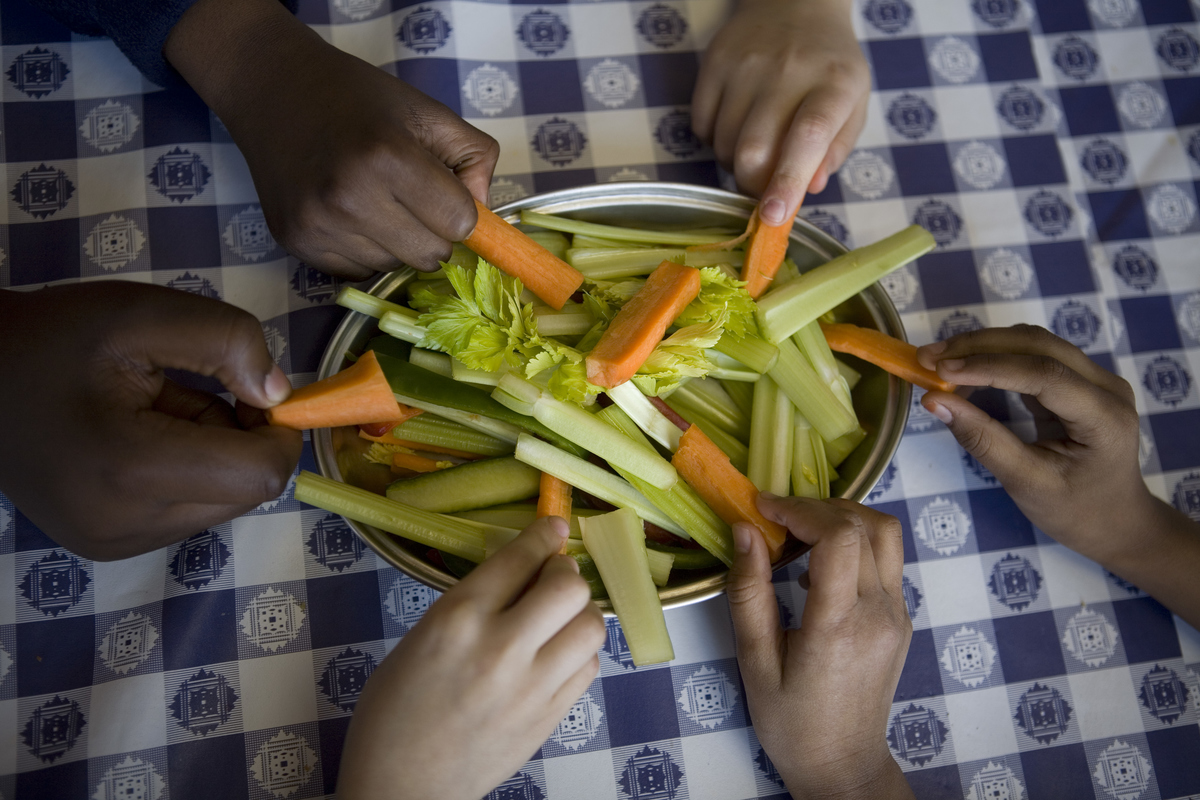Pupils from Millfields Community School help themselves from the bowl of fresh organic carrots, cucumbers and celery