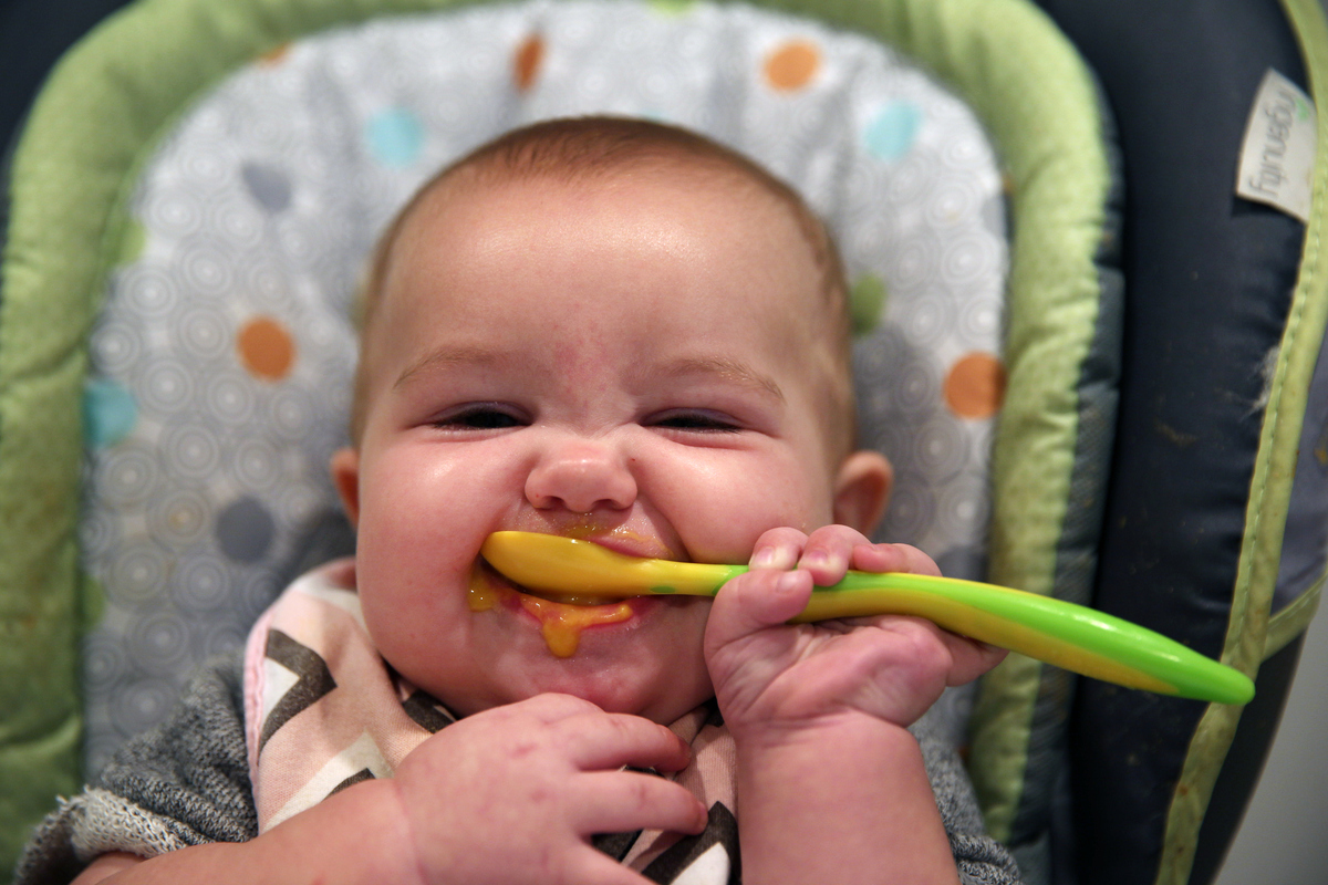 A nine month old baby girl at meal time.