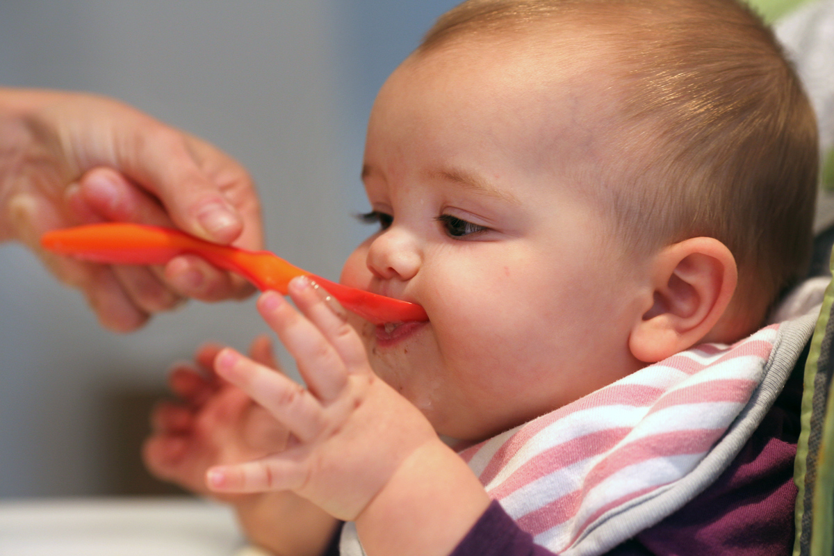 A nine month old baby girl at meal time.