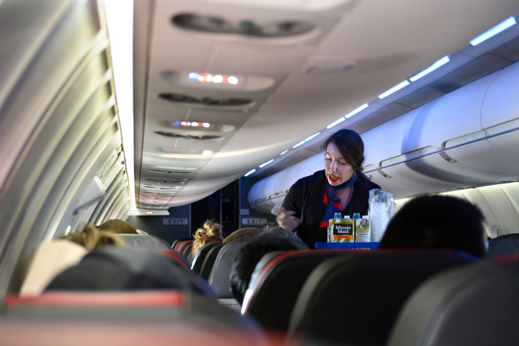 A Flight Attendant Offers Beverages