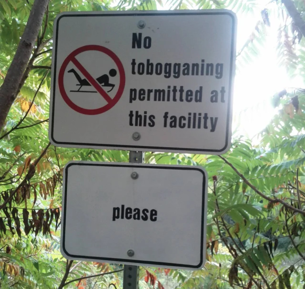 Sign reads: NO tobogganing permitted at this facility please 