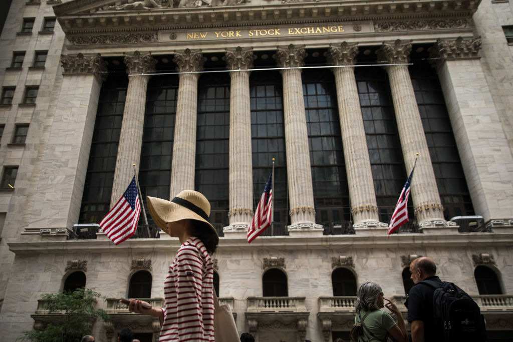 A woman walks past the New York Stock Exchange (NYSE)