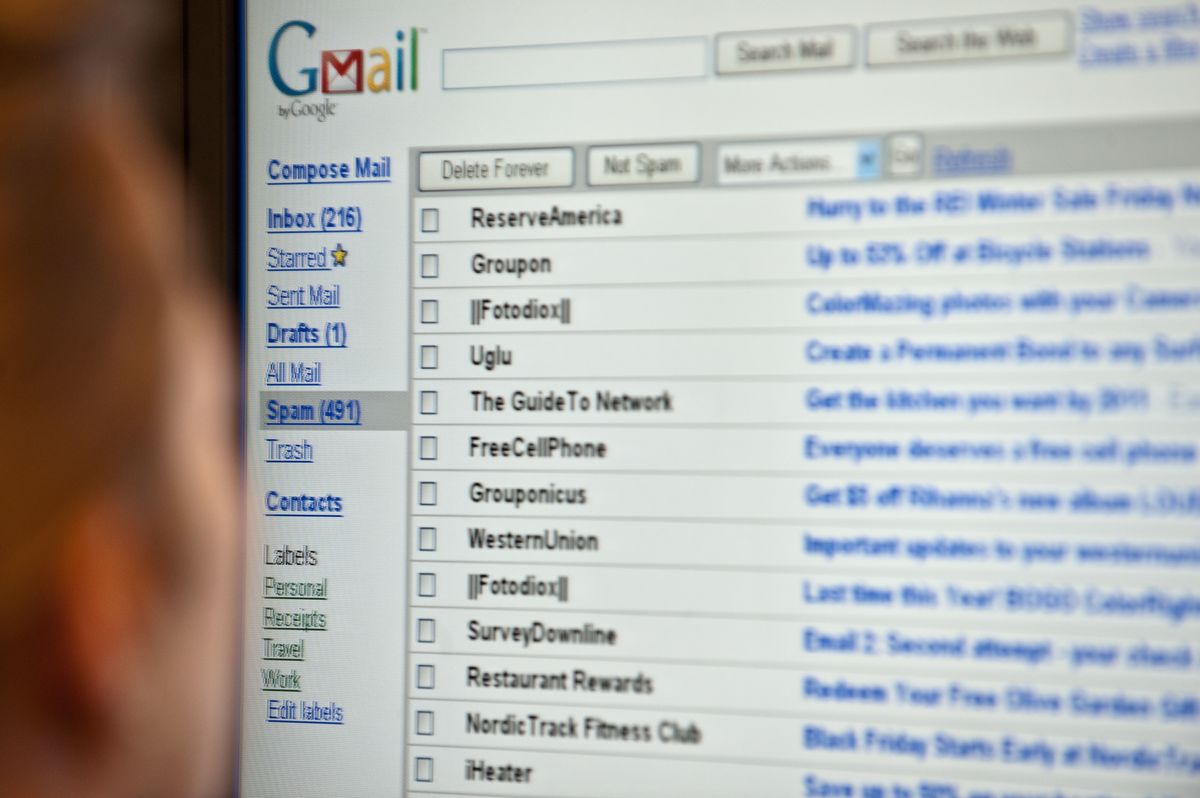 A woman looks at her email on a computer screen.