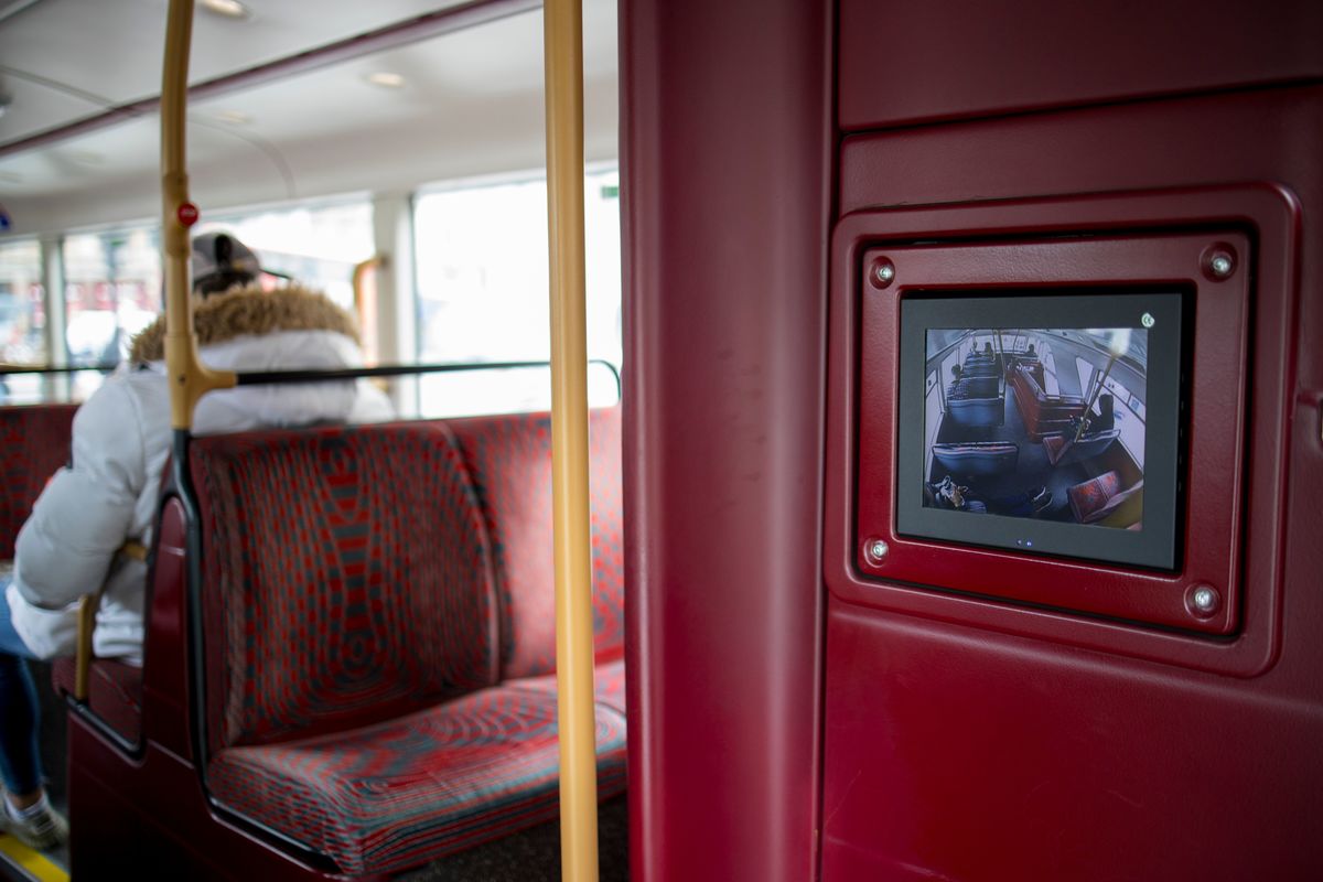 A monitor shows CCTV live feed on a double decker London bus.