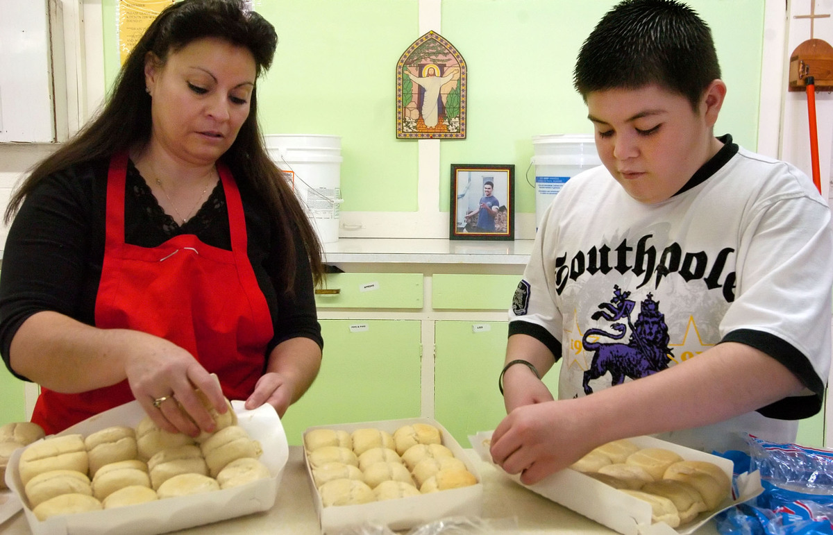 Judy Padilla , left, butters rolls with her grandson, Santino Padilla.