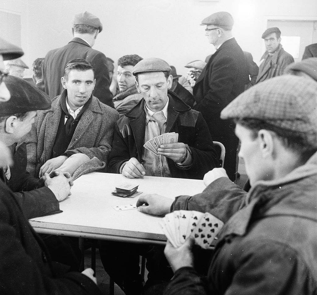 a group of men playing cards on the dock