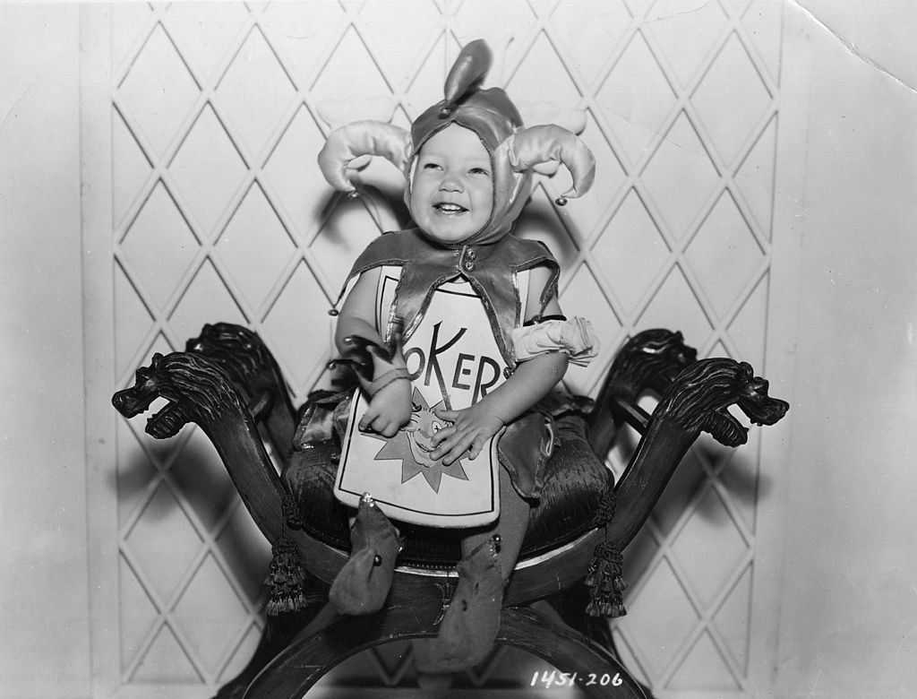 a baby dressed as a joker playing card