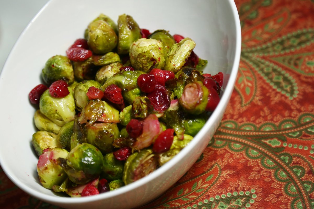 Roasted Brussels sprouts and cranberries are in a white bowl. 