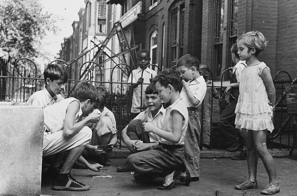 a group of kids playing cards on the street