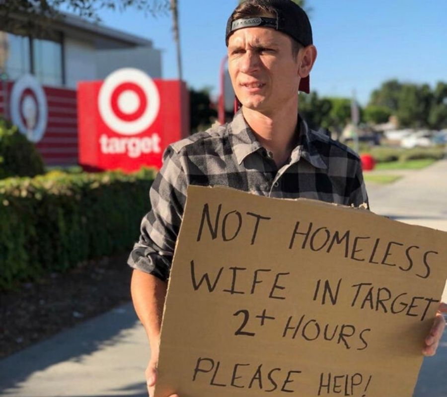 a husband with a sign about his wife being in target 