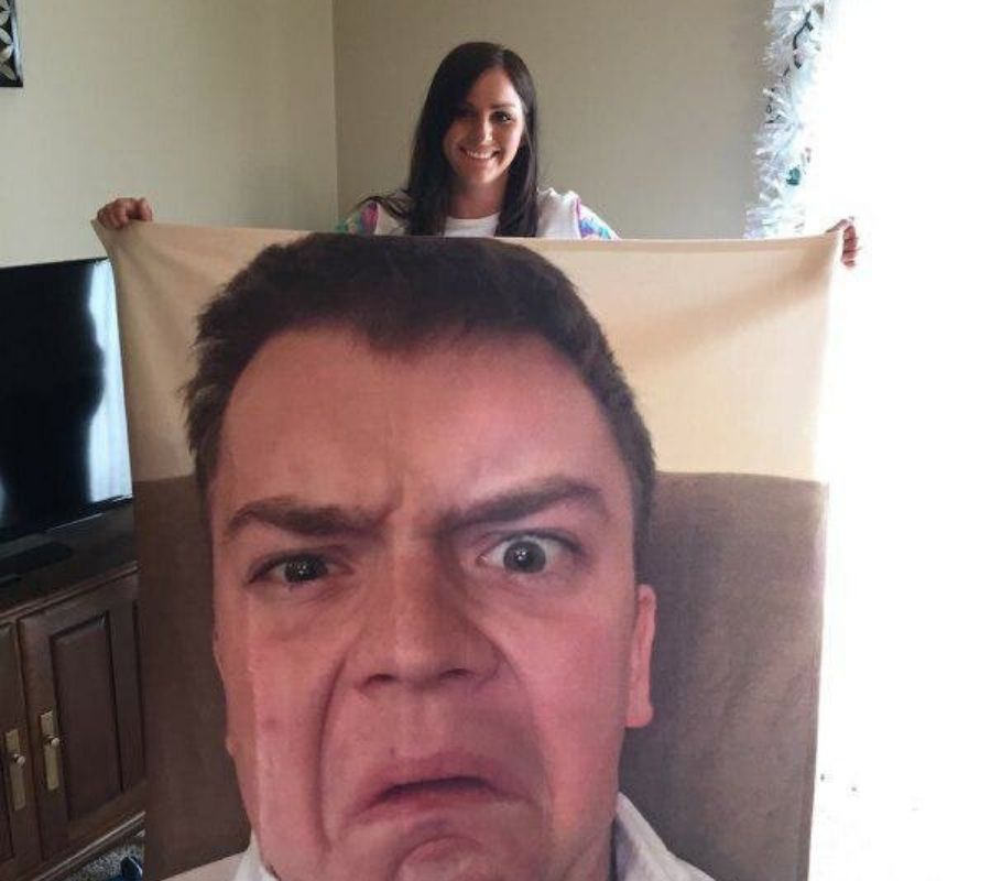 a girl holding a blanket with her dad's face on it