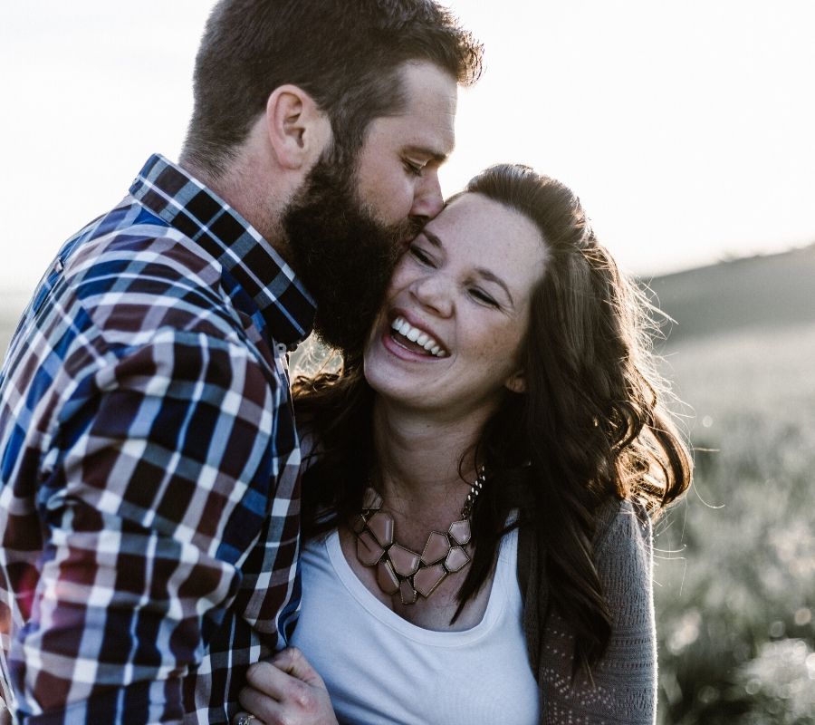 a couple laughing and kissing