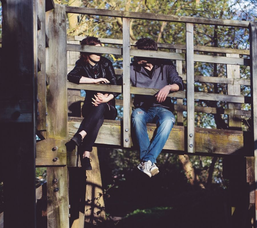 a couple sitting on a bridge