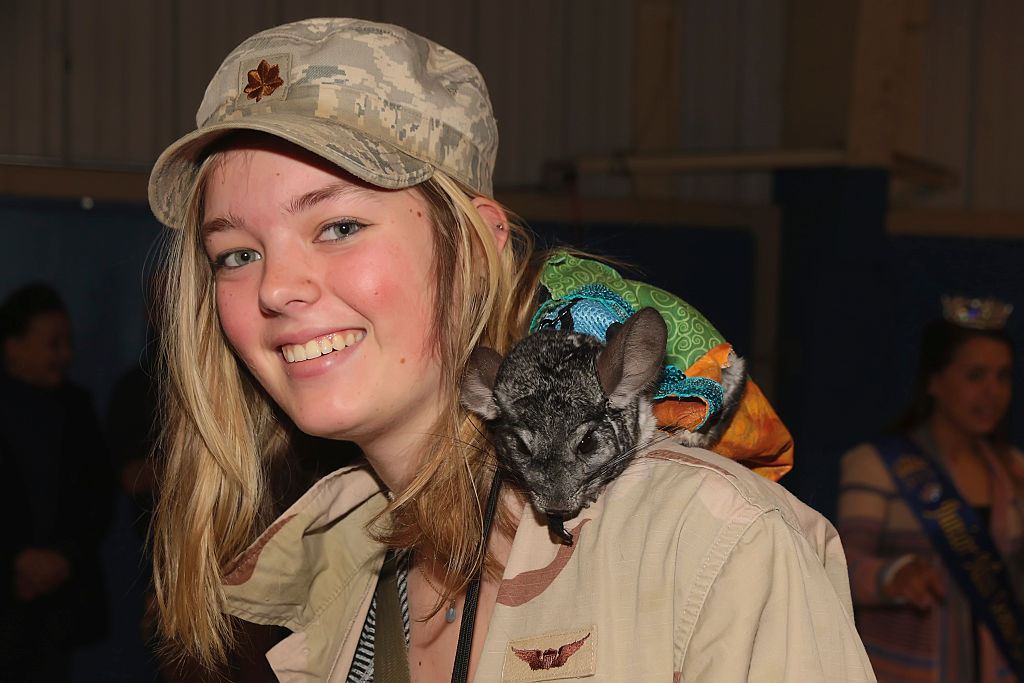 a blonde girl with a chinchilla on her shoulder
