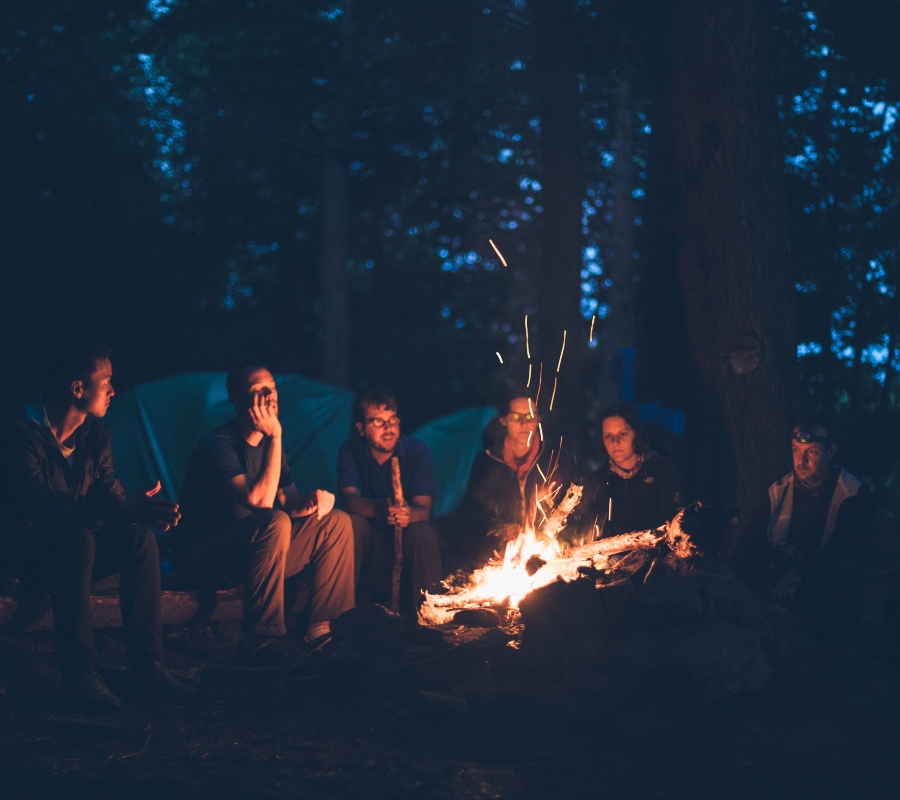 a group of friends sitting around a fire