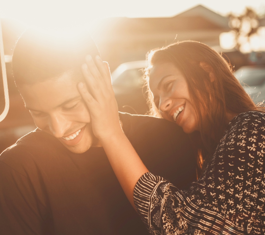 a couple laughing at sunset 