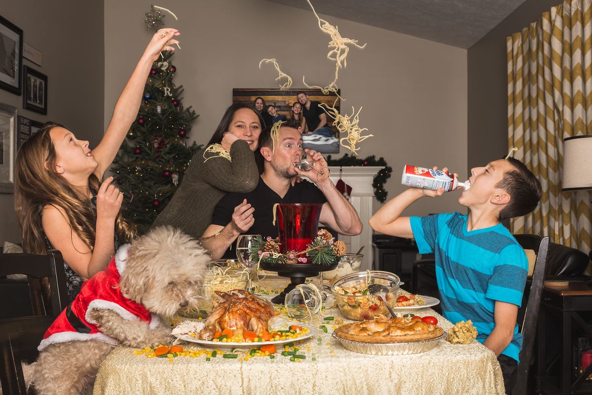 family eating dinner throwing spaghetti at table