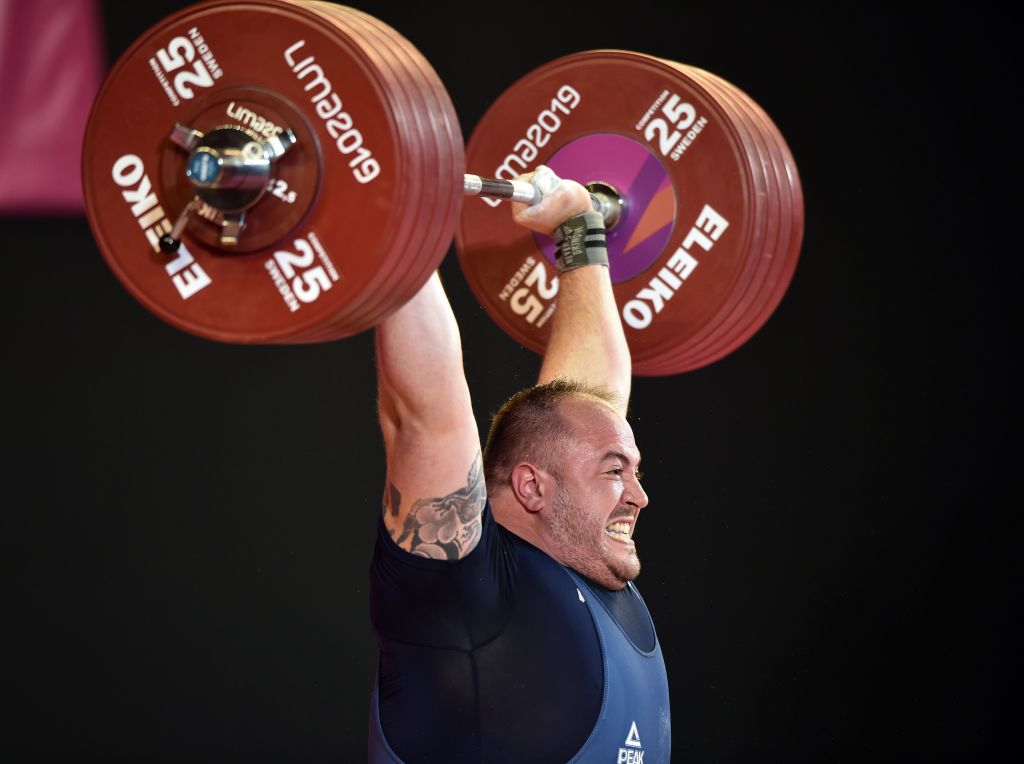 A man struggles to hold up heavyweights.