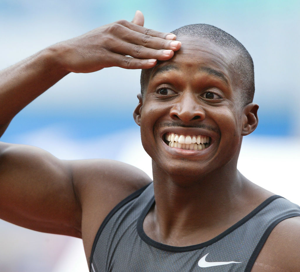 A man holds a hand to his head and looks livid.