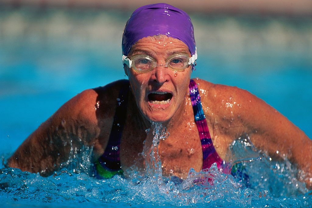 A female swimmer emerges from the water for air.