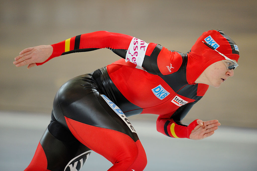 An athlete bends down to speed skate.