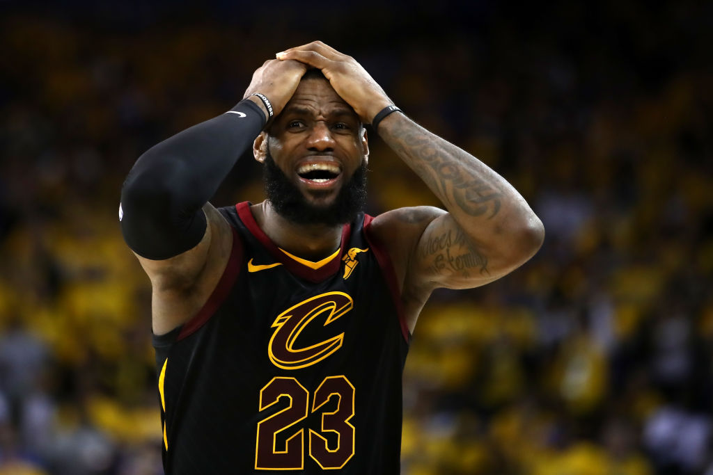 LeBron James puts his hands to his head and looks upset during a basketball game.