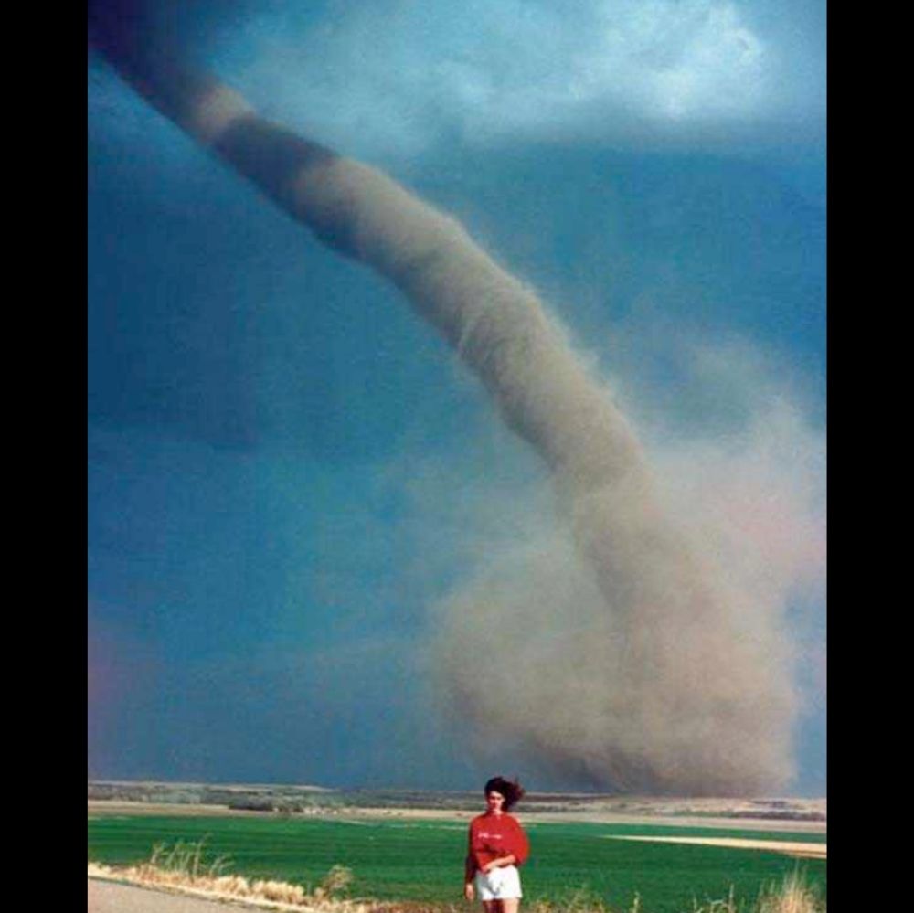 funnel cloud touching down behind woman