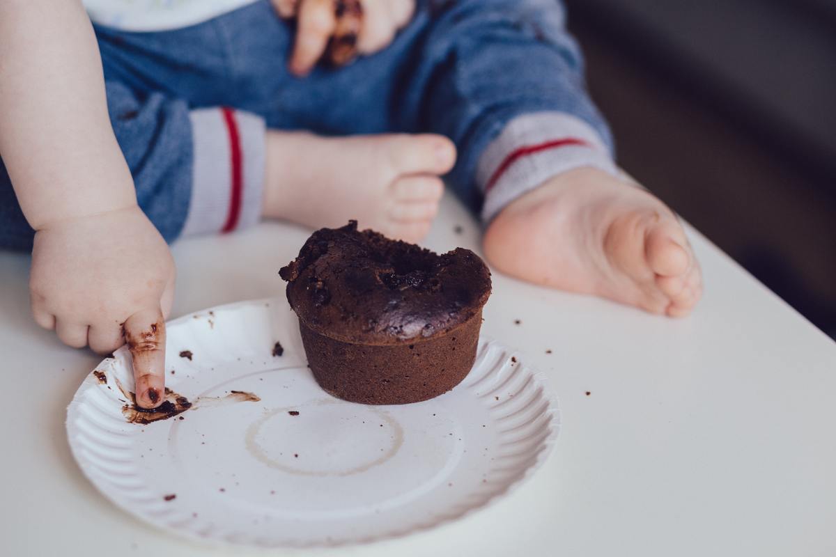 kid smudging chocolate on paper plate