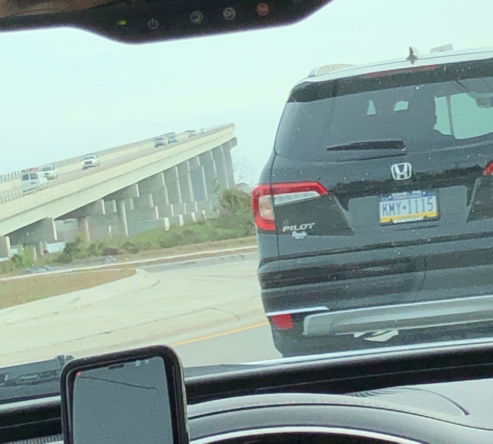 cars driving up on a bridge that doesn't lead anywhere