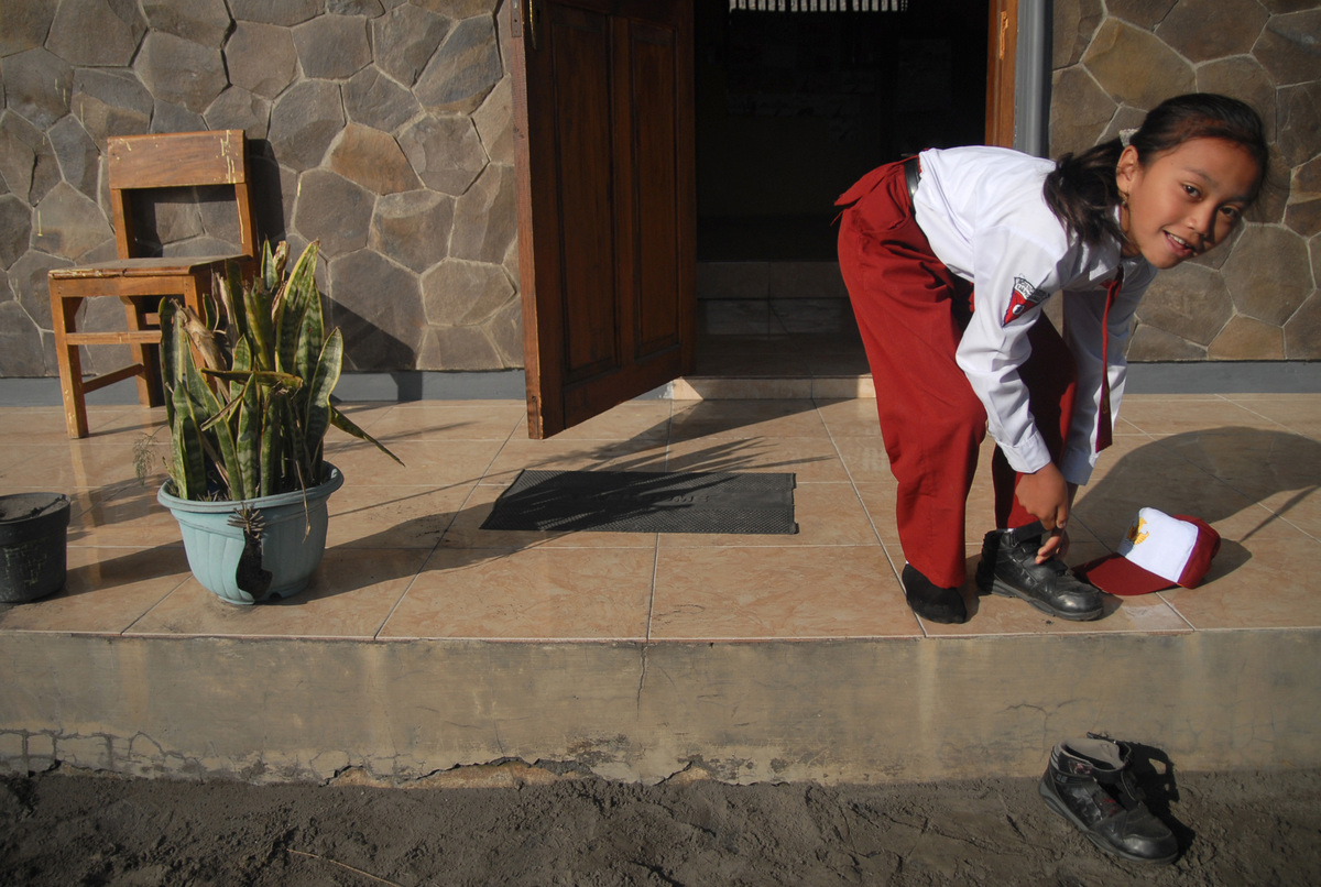 Students take off shoes before entering the classroom