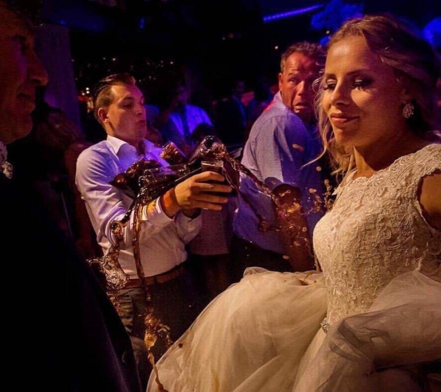 someone spilling drinks on a bride