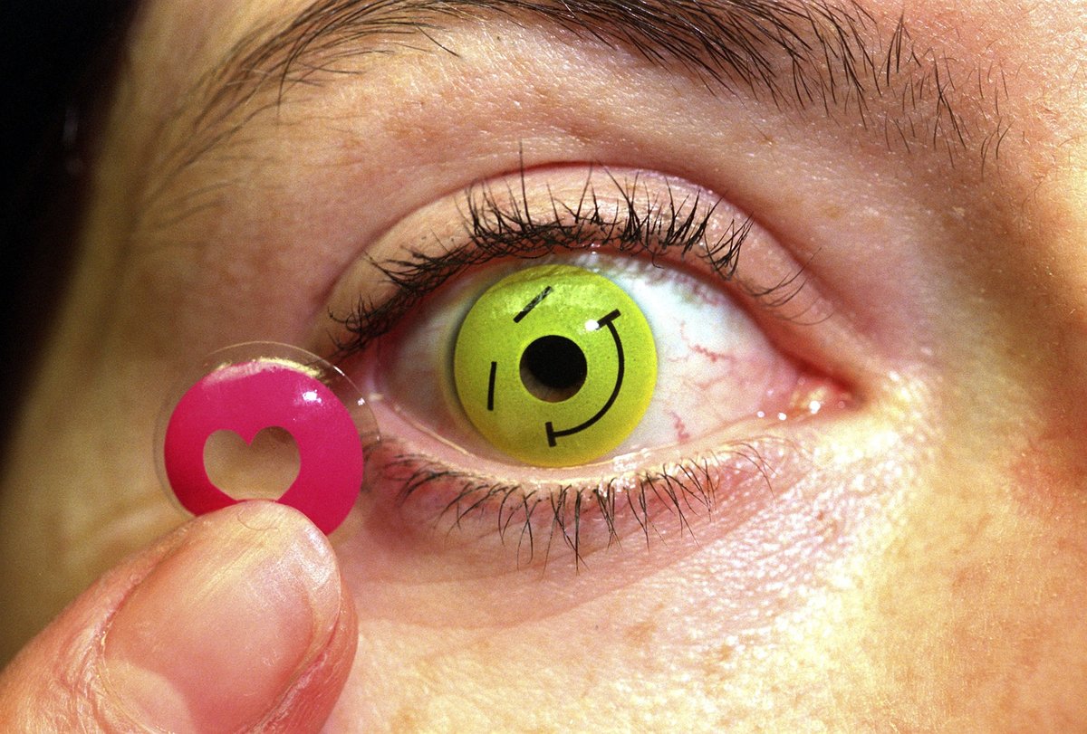A woman puts in colored contact lenses.