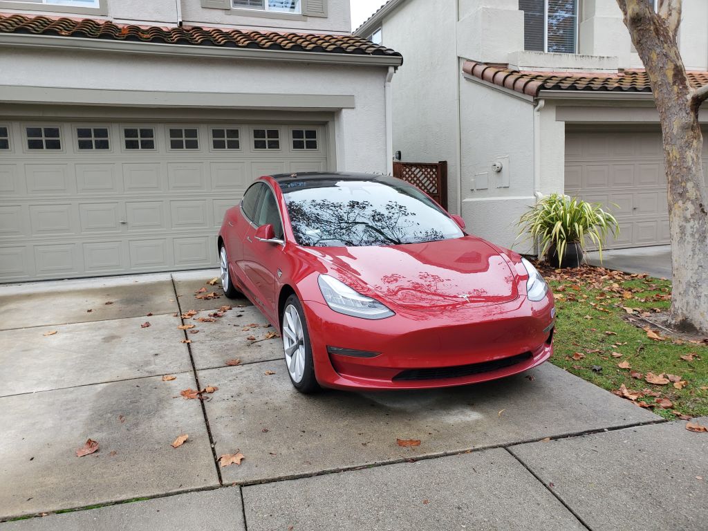 A car is parked backwards in a driveway.